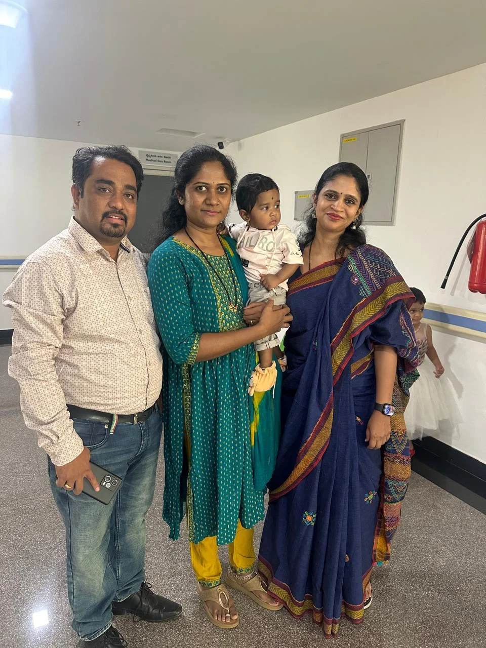 A family photographed with Dr. Aruna at the clinic